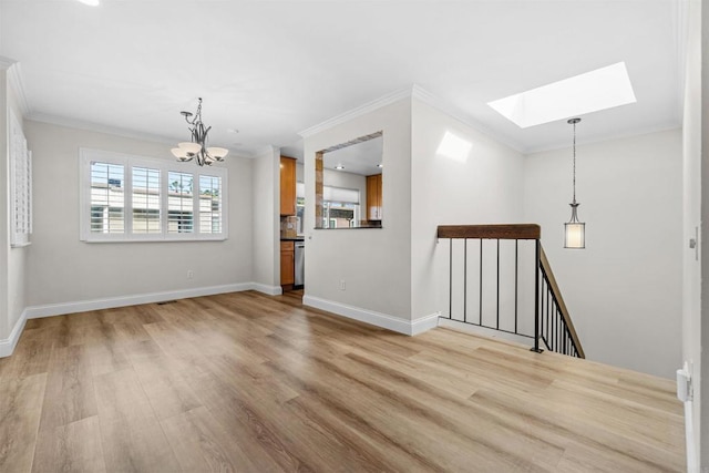 unfurnished living room with light hardwood / wood-style floors, ornamental molding, a skylight, and a chandelier