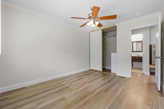 unfurnished bedroom featuring ceiling fan, stacked washer / dryer, light wood-type flooring, and crown molding