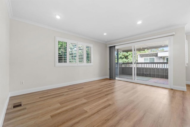 empty room featuring crown molding and light hardwood / wood-style floors