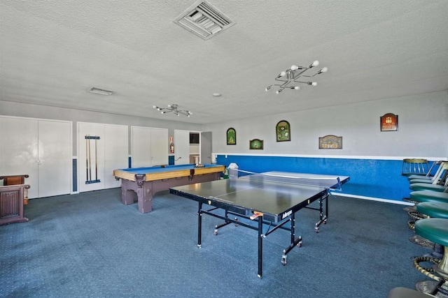 rec room with billiards, a textured ceiling, and dark colored carpet