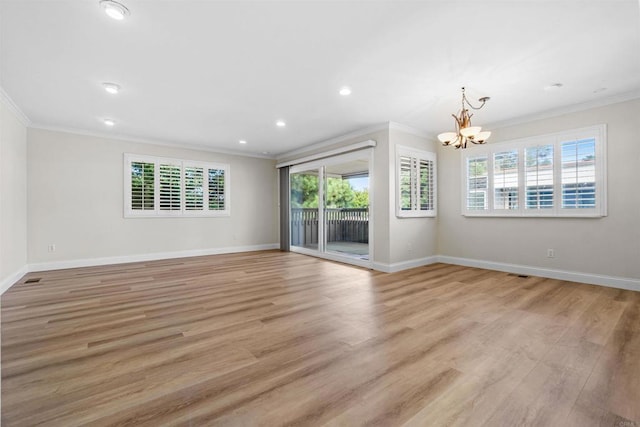 spare room with a notable chandelier, ornamental molding, and light wood-type flooring