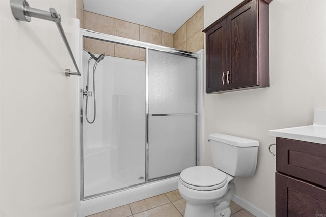 bathroom with vanity, a shower with door, tile patterned floors, and toilet