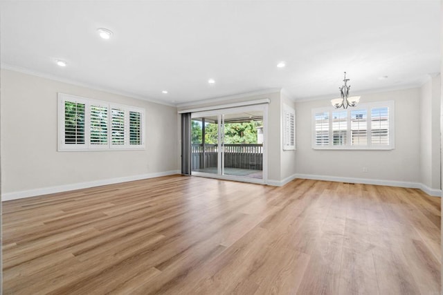 unfurnished living room with crown molding, an inviting chandelier, and light hardwood / wood-style floors