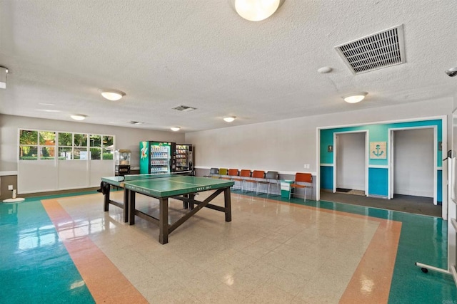 recreation room with a textured ceiling