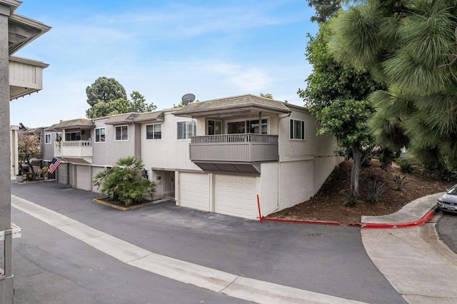 6309 Caminito Salado, San Diego, CA 92111 - townhome / multi-family property featuring a balcony, an attached garage, stucco siding, and asphalt driveway