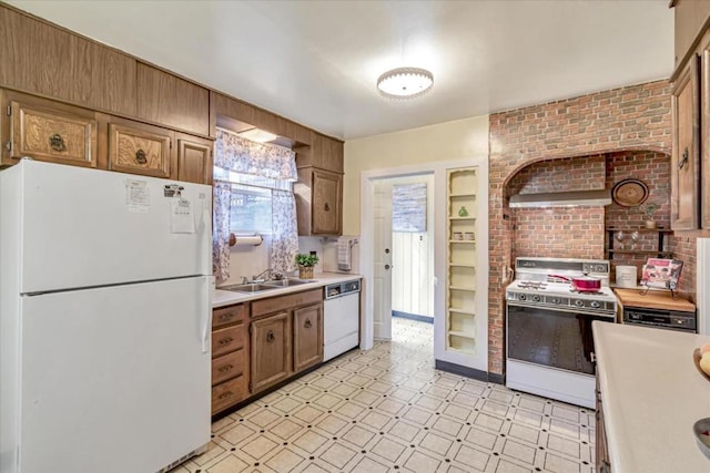 kitchen with brick wall, sink, and white appliances