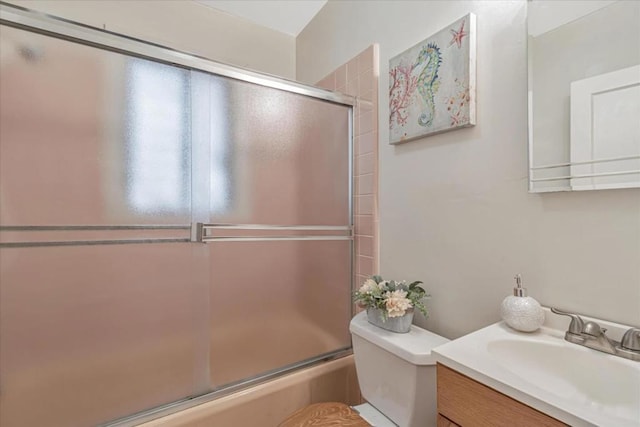 bathroom featuring a shower with shower door, toilet, and vanity