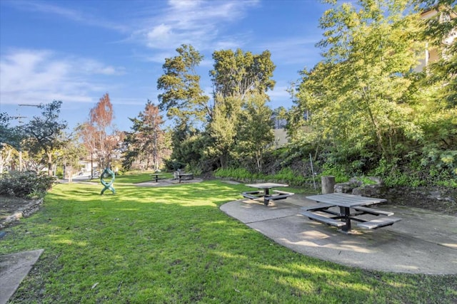 view of home's community featuring a lawn and a patio area