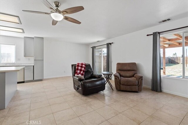 living area featuring light tile patterned flooring, ceiling fan, and a wealth of natural light