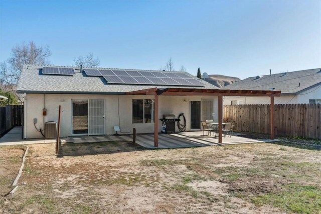 rear view of house with a patio area and solar panels