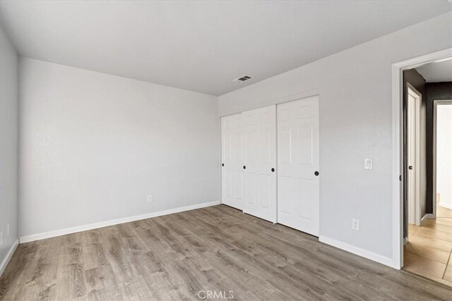 unfurnished bedroom featuring a closet and hardwood / wood-style floors