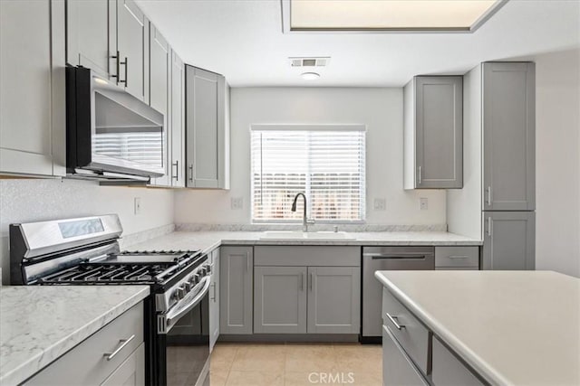 kitchen with sink, gray cabinets, stainless steel appliances, and light tile patterned flooring