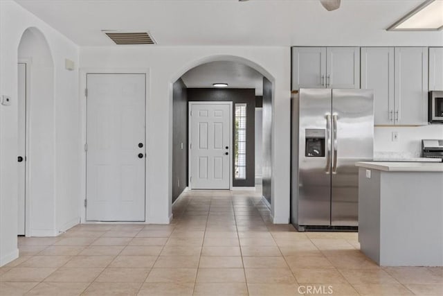 kitchen with light tile patterned floors, gray cabinets, and appliances with stainless steel finishes