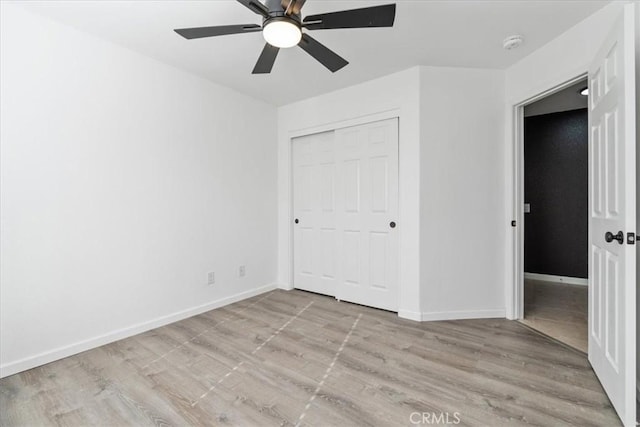 unfurnished bedroom with ceiling fan, a closet, and light hardwood / wood-style flooring