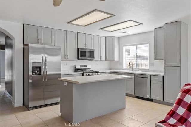 kitchen featuring sink, gray cabinets, a center island, and appliances with stainless steel finishes