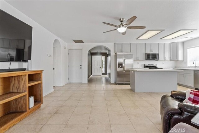 kitchen featuring ceiling fan, appliances with stainless steel finishes, gray cabinetry, and a kitchen island