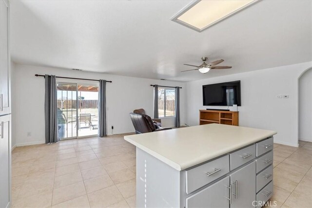 kitchen with ceiling fan, a wealth of natural light, gray cabinetry, and a kitchen island