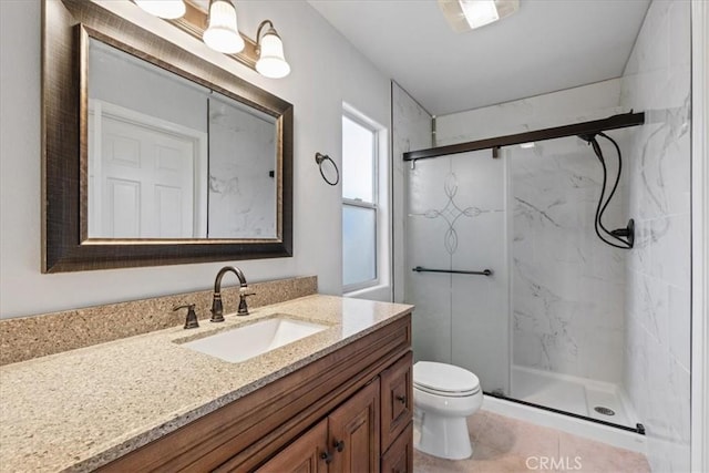 bathroom featuring vanity, a shower with shower door, and toilet