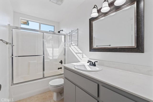 full bathroom with tile patterned flooring, enclosed tub / shower combo, vanity, and toilet