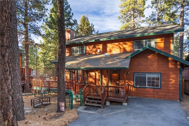 rear view of property featuring a wooden deck