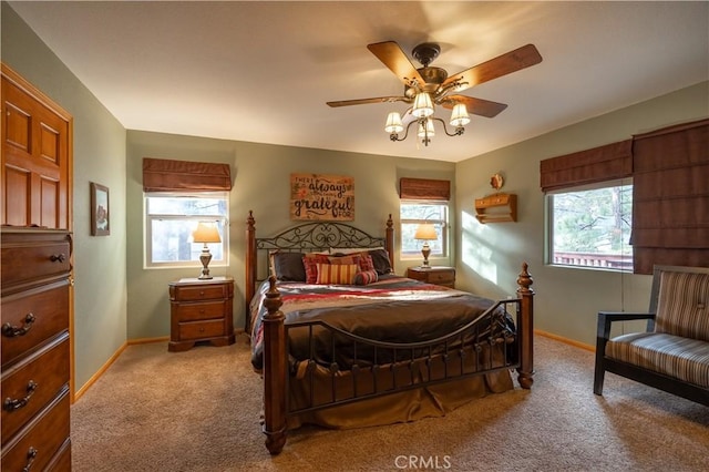 carpeted bedroom featuring ceiling fan and multiple windows