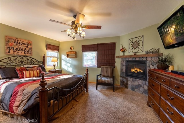 bedroom featuring ceiling fan, light colored carpet, and a fireplace