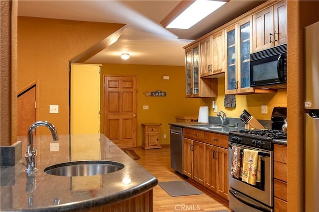 kitchen featuring stainless steel appliances, light hardwood / wood-style floors, and sink