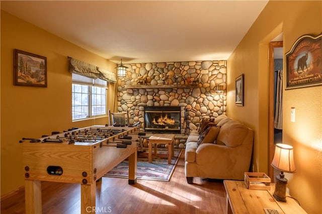 game room featuring a fireplace and hardwood / wood-style flooring