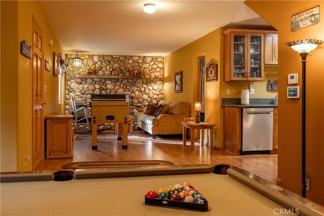 workout area featuring pool table, hardwood / wood-style flooring, and a stone fireplace