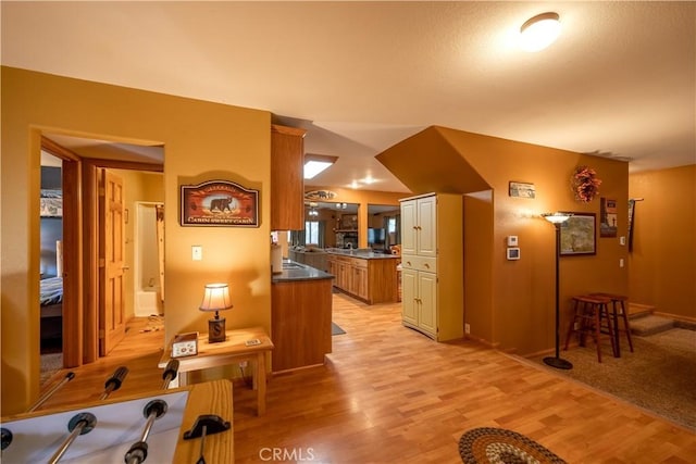 kitchen with a kitchen bar and light hardwood / wood-style flooring