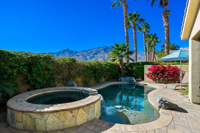 view of swimming pool featuring a mountain view and an in ground hot tub