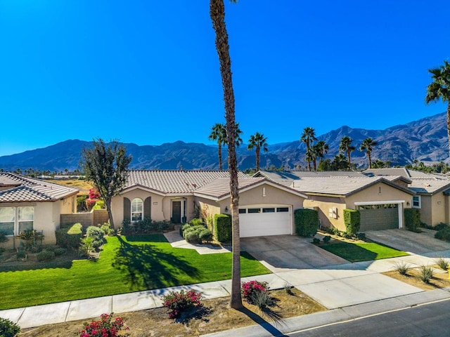 view of front of house featuring a front lawn, a mountain view, and a garage