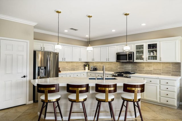 kitchen featuring a center island with sink, a breakfast bar, sink, stainless steel appliances, and white cabinets