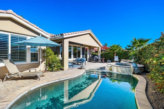 view of swimming pool featuring a patio and an in ground hot tub