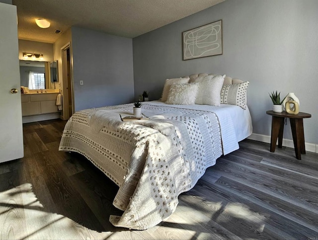 bedroom featuring dark hardwood / wood-style floors, connected bathroom, and a textured ceiling