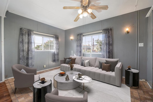 living room featuring ceiling fan and a healthy amount of sunlight