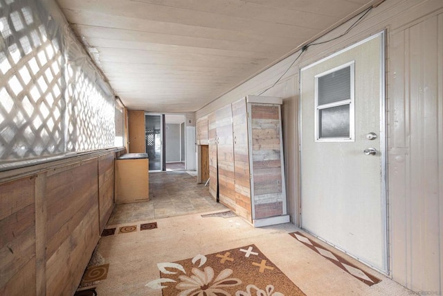 hallway featuring wood walls