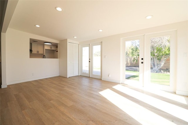 unfurnished room with light wood-type flooring and french doors