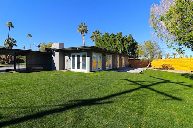 back of house with french doors and a yard