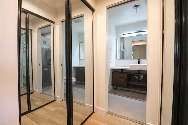 bathroom featuring wood-type flooring, toilet, and vanity