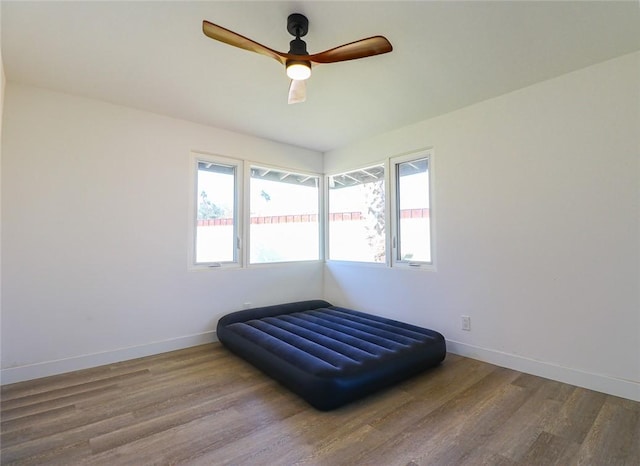 bedroom with ceiling fan, multiple windows, and wood-type flooring