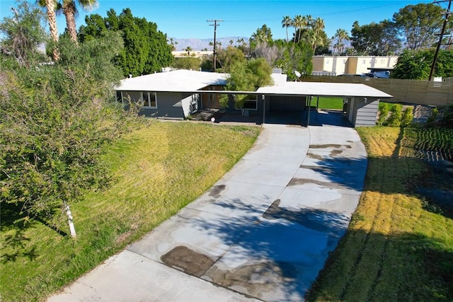 view of front of house featuring a carport and a front yard