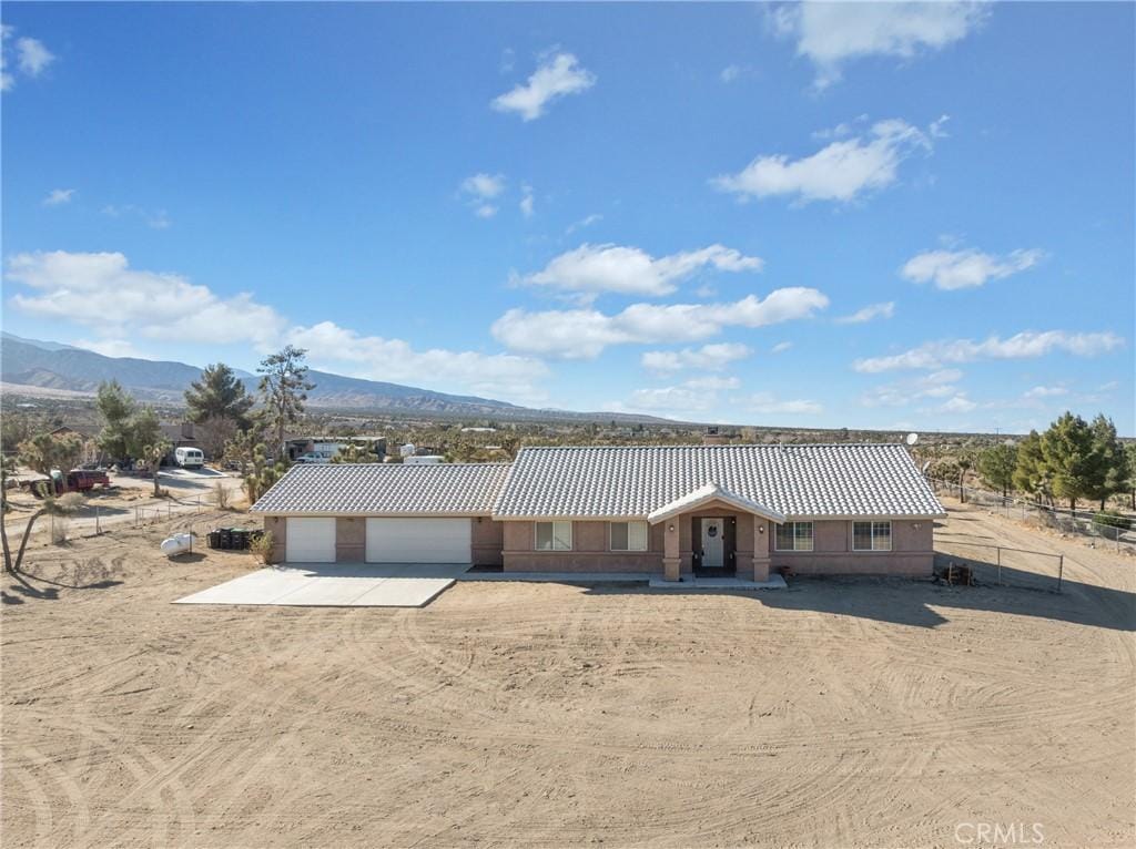 ranch-style home with a garage and a mountain view