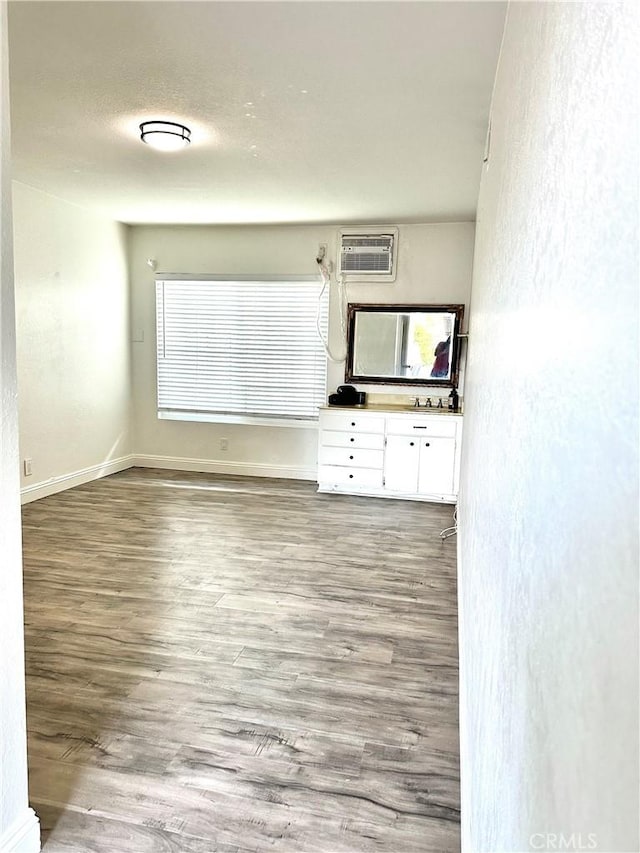 interior space with a wall mounted AC and wood-type flooring