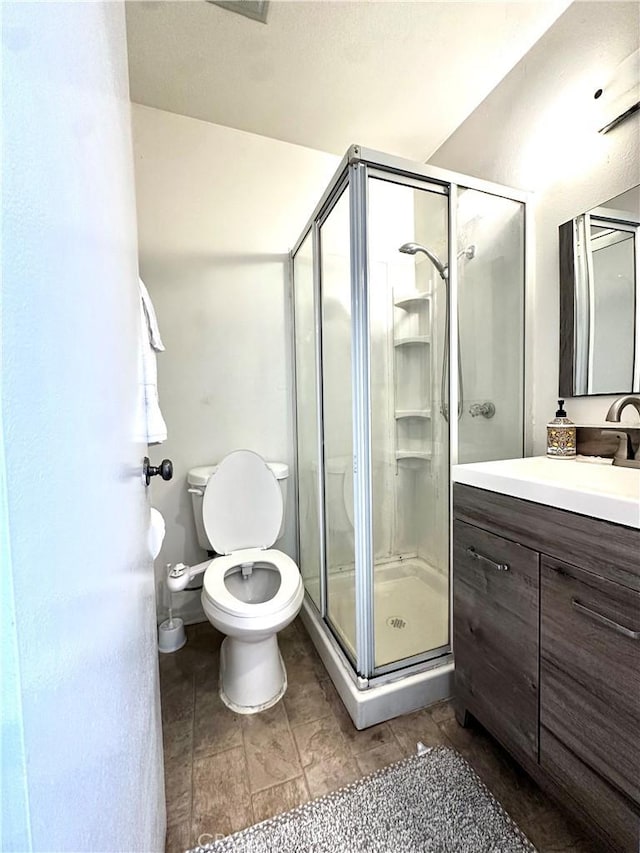 bathroom with toilet, walk in shower, and vanity