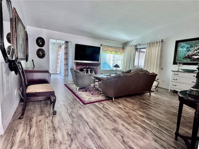 living room featuring hardwood / wood-style flooring and a brick fireplace