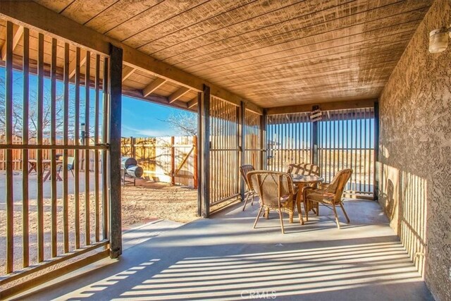 exterior space with beam ceiling and wood ceiling