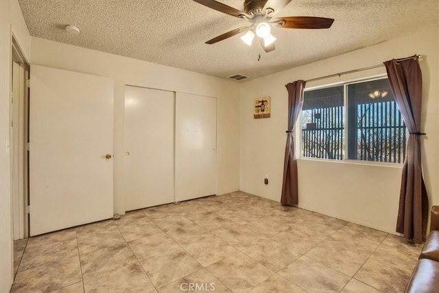 unfurnished bedroom featuring ceiling fan, a closet, and a textured ceiling