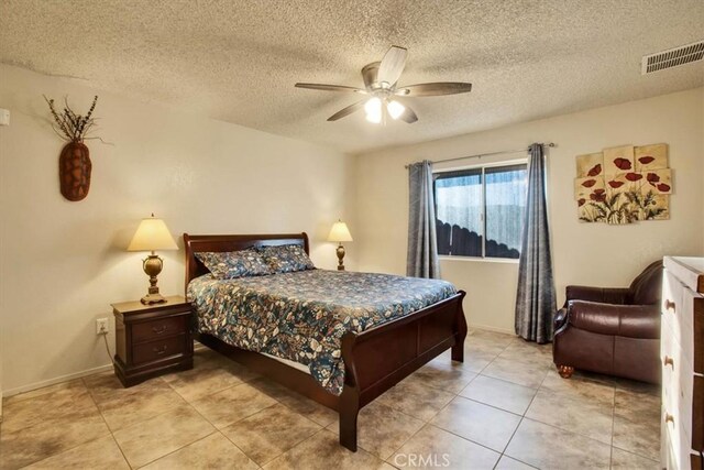 tiled bedroom featuring a textured ceiling and ceiling fan