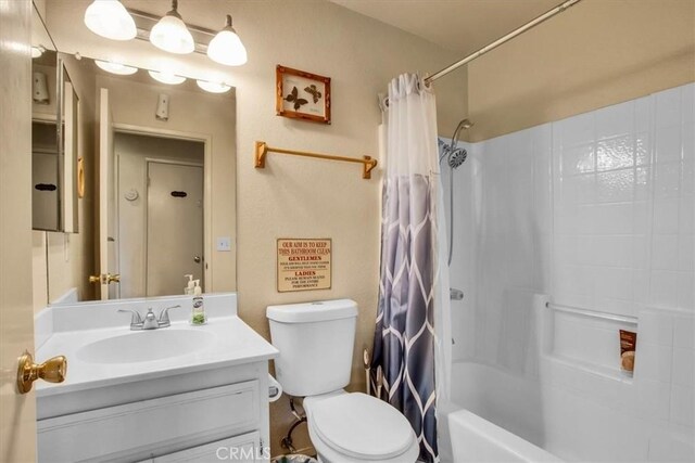 full bathroom with toilet, vanity, and shower / bath combination with curtain